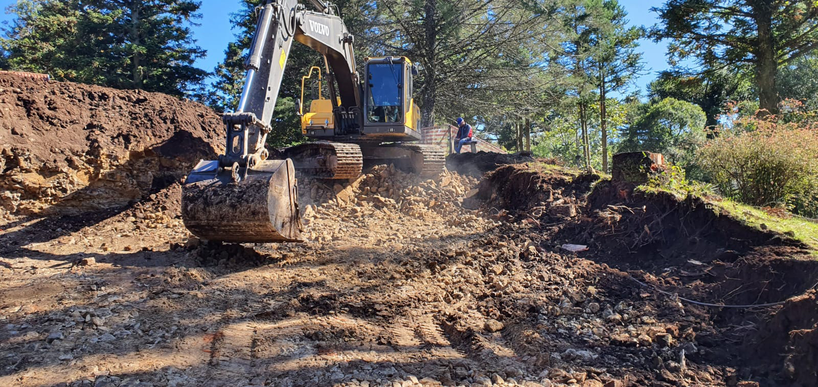 Máquina fazendo escavação no terreno nas obras do Poehma Lago Negro