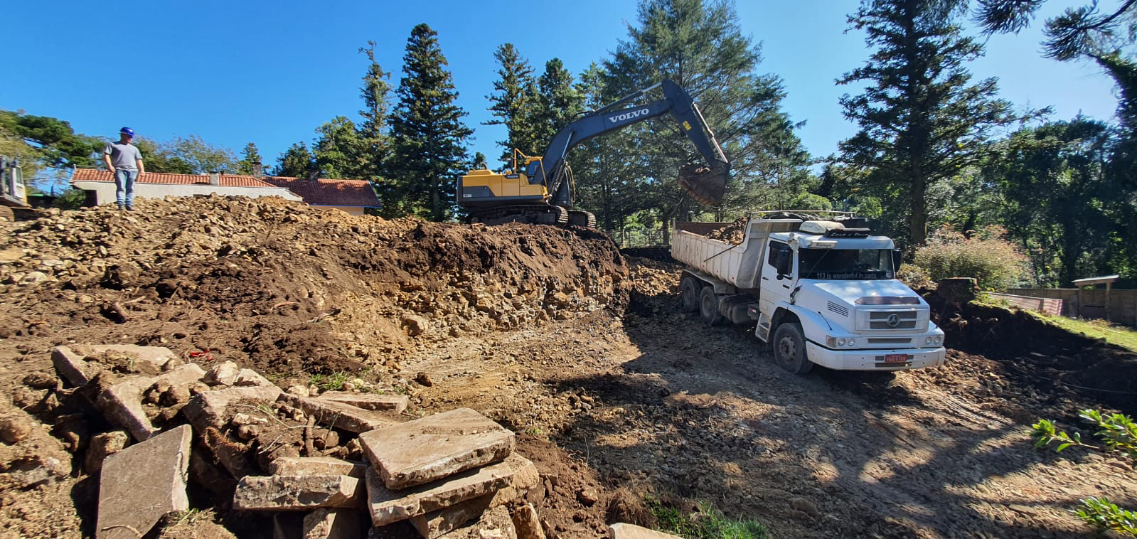 Máquina colocando a terra no caminhão, parte do processo de escavação das obras do Poehma Lago Negro